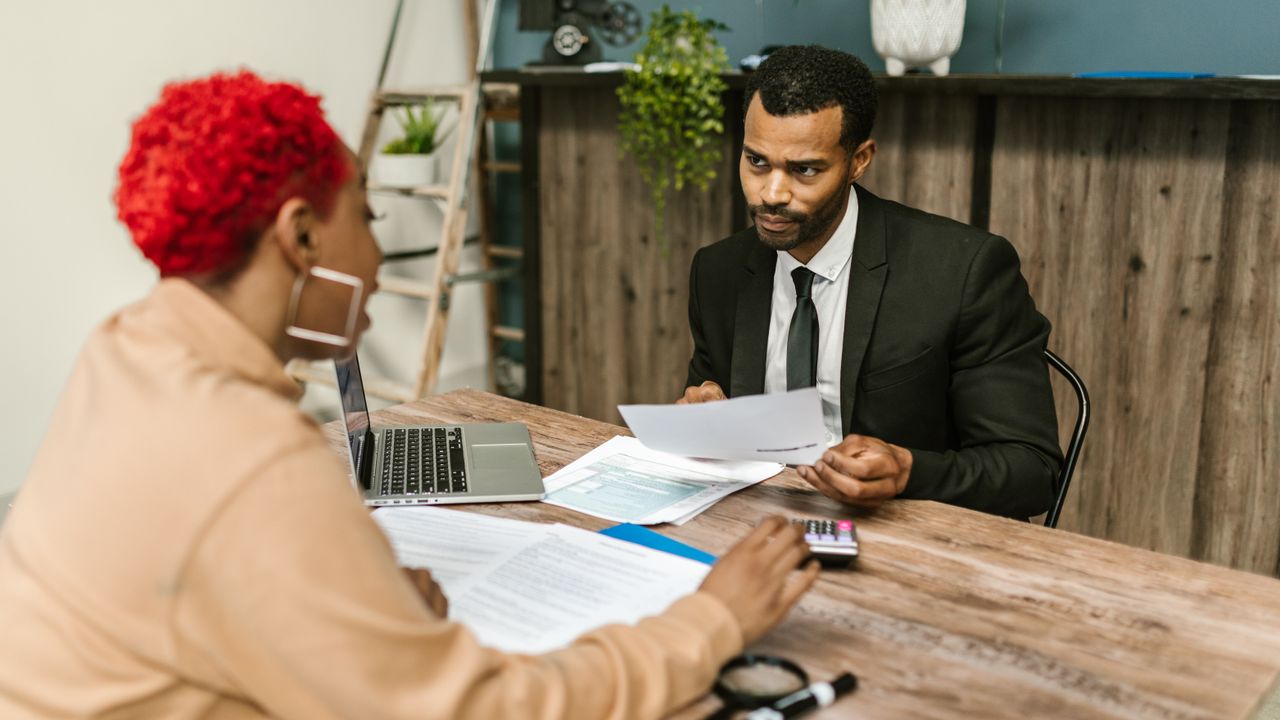 Tax advisor reviewing return paperwork with a client at a table