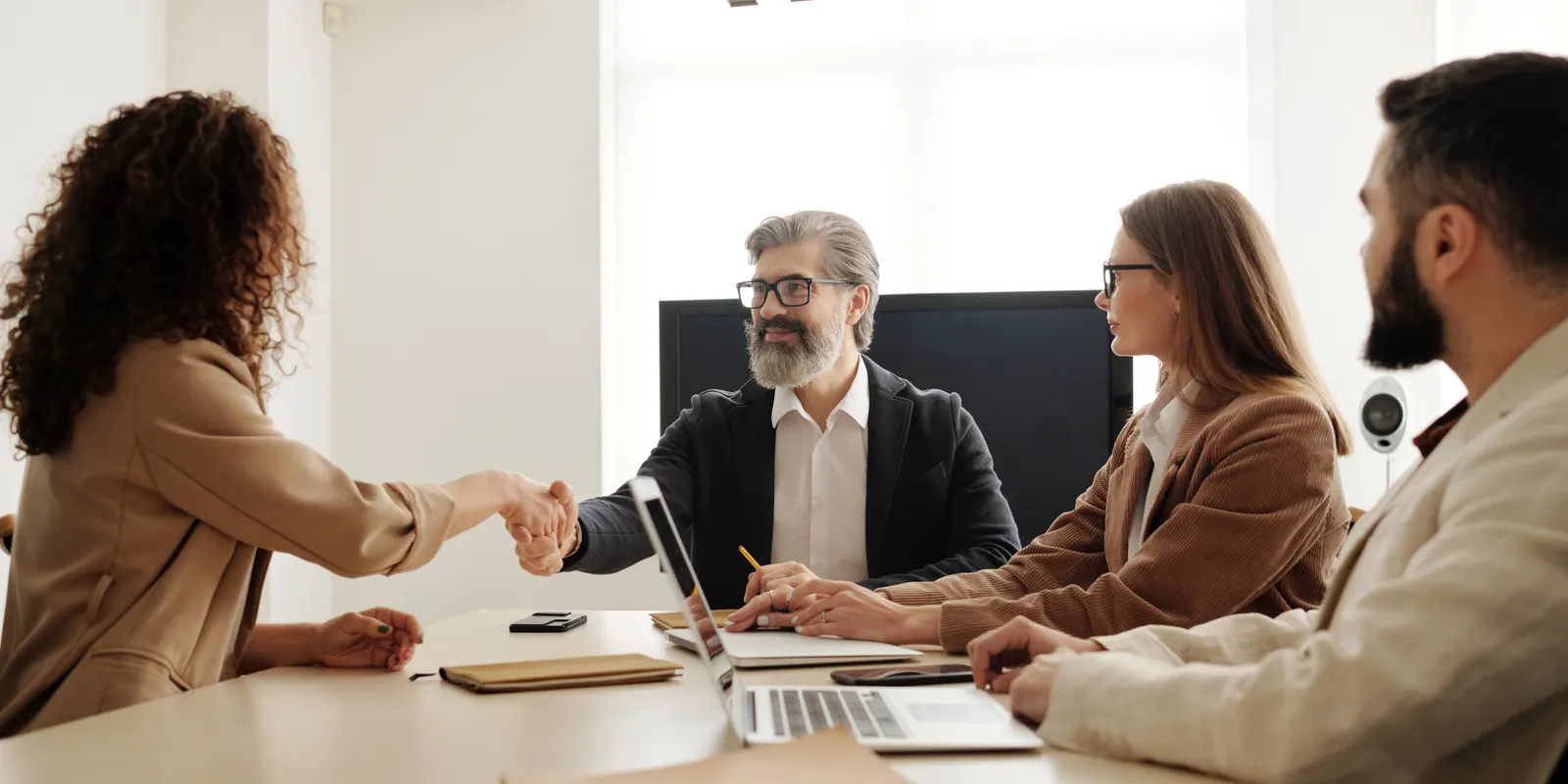 Accountants shaking hands with business clients during a meeting